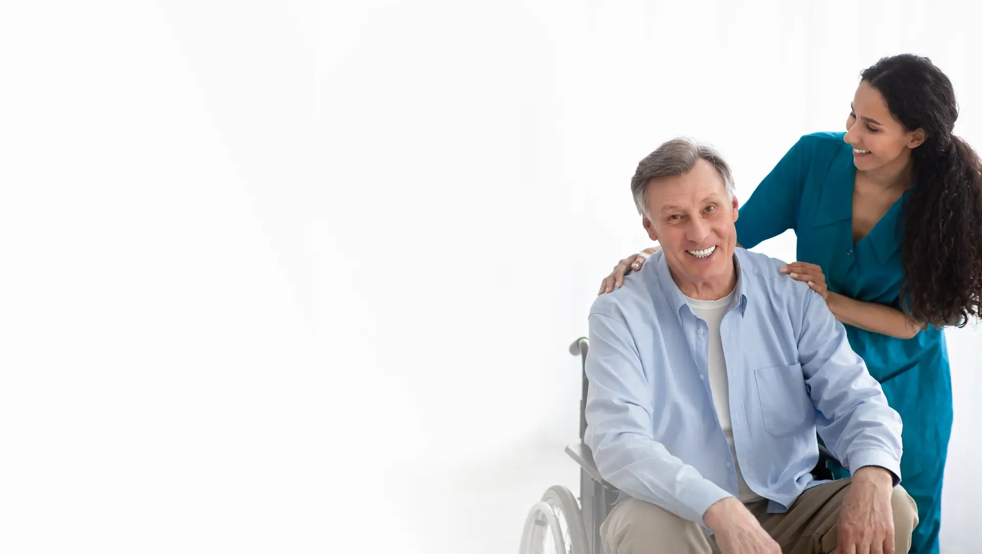 A caregiver supporting an older man seated in a wheelchair
