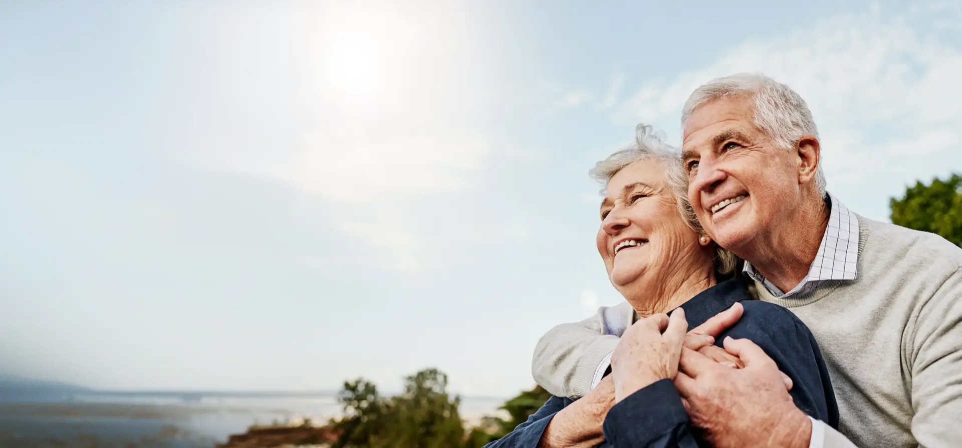 An older couple smiling together outdoors