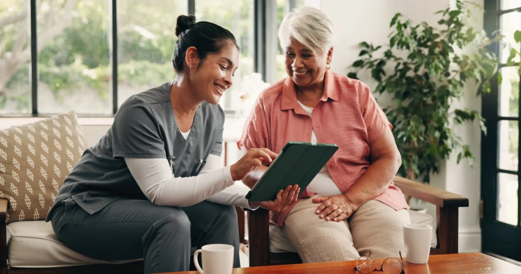 A nurse and an older woman reviewing a tablet together